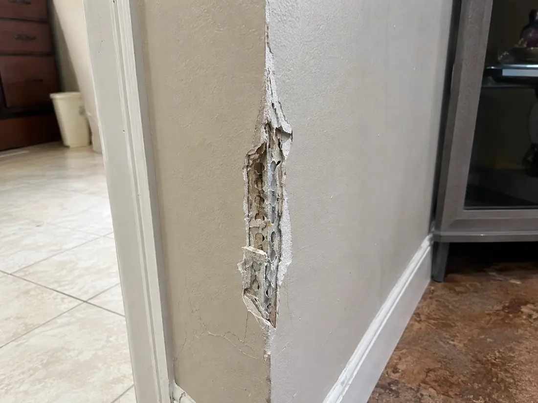 Damaged drywall corner bead with cracked compound